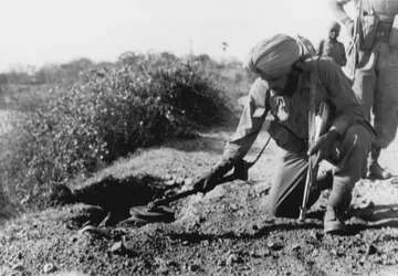 Ein indischer Soldat sucht mit einem Metalldetektor nach Minen
